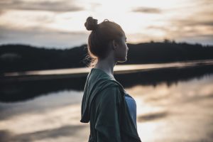 a-side-view-of-a-woman-standing-near-the-lake
